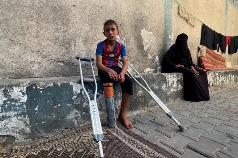 تقرير:  راتب طفل غزّي يحاول تعويض ساقه المبتورة بأنبوب بلاستيكي